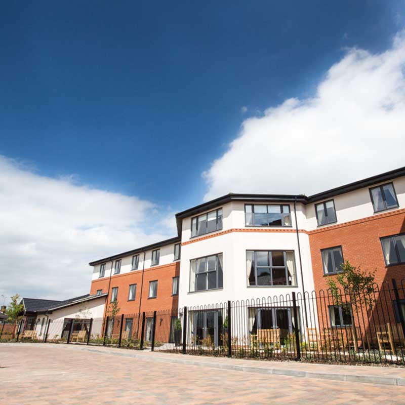 Three storey modern building complex with blue sky above